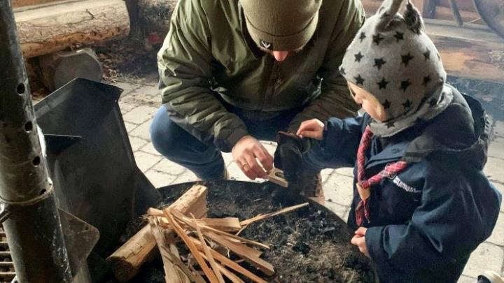 Båltænding ved familiespejder - far og barn tænder bål